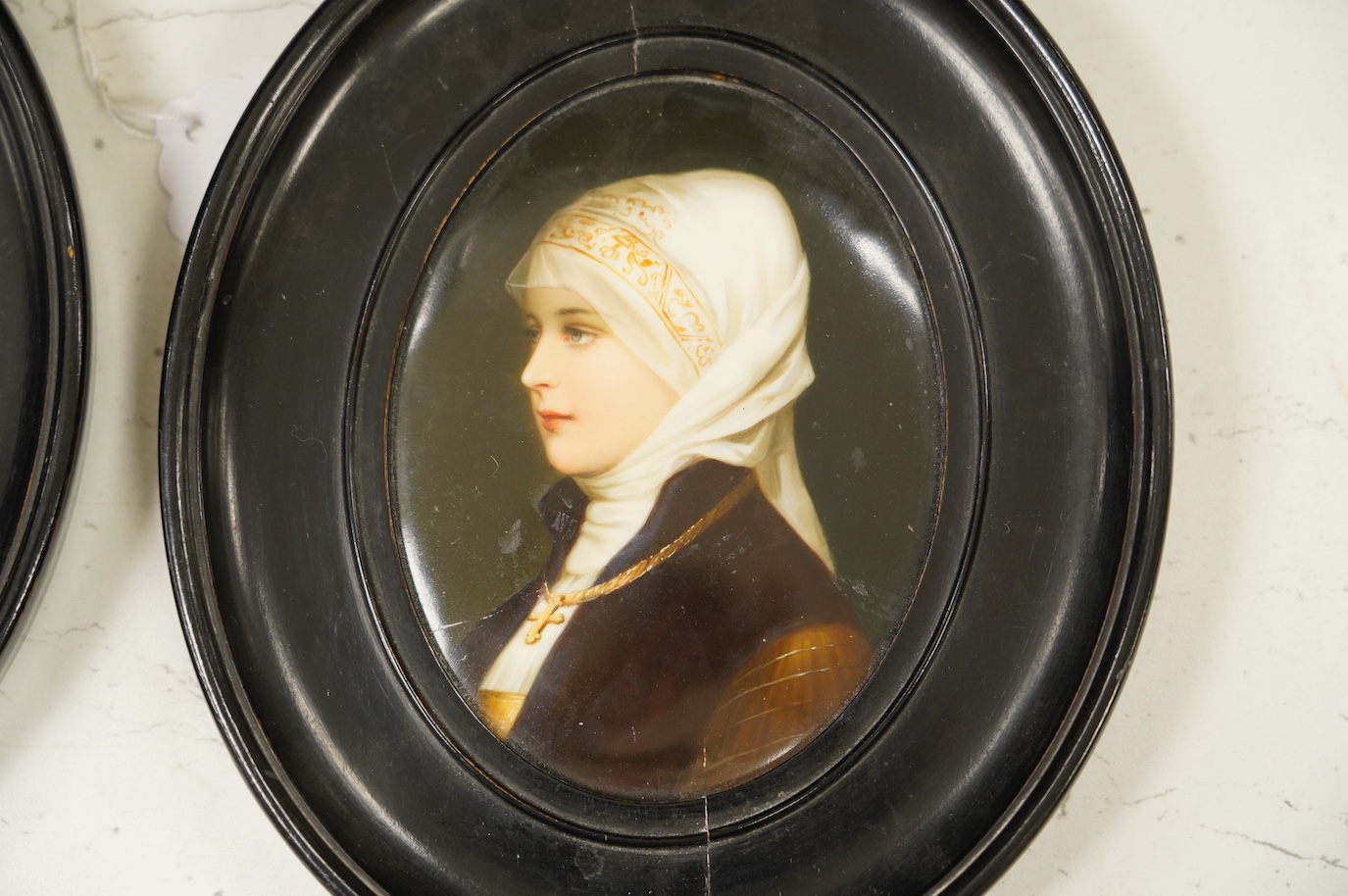 A pair of mid 19th century Paris porcelain plaques decorated with portraits of female figures, both in oval ebonised frames. Condition - fair to good